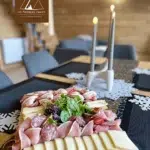 "Plateau gourmand pour raclette avec charcuteries et fromages locaux aux Atypiques Chalets"