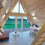 Intérieur du chalet Iorik A-Frame avec canapé cosy et vue sur la nature vosgienne
