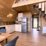Cuisine équipée et entrée du chalet Aslan avec escalier en bois brut