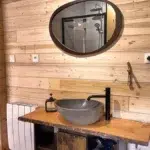 Salle de bain du Chalet Charkhan avec meuble vasque en pierre naturelle et douche moderne, Atypiques Chalets Gérardmer.