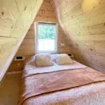 Chambre en mezzanine du chalet A-Frame Iorik, lit double sous la charpente en bois, à 10 min de Gérardmer